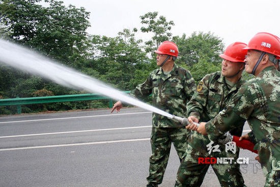 (2015年5月13日，湖南省涟源市桥头河镇消防队队员们在进行消防训练。