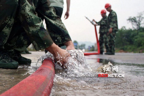 (湖南省涟源市桥头河镇消防队队员们训练收装消防水管。)